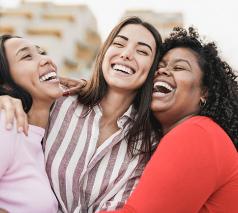 Three female friends hugging and laughing after using their in-house membership plan in Conyers (