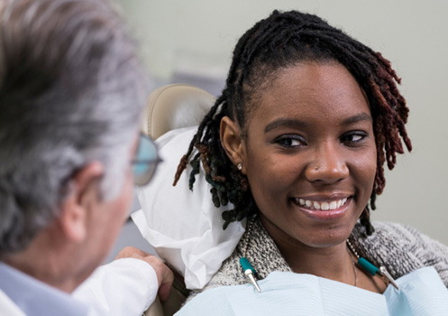 Young female sitting in the dentist’s chair 