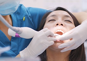 A woman undergoing scaling and root planing treatment