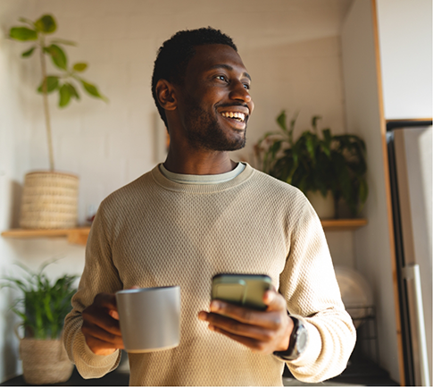 Man in sweater smiling and holding coffee cups