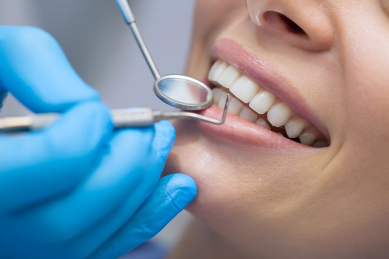 A dentist preparing to perform a patient’s teeth cleaning